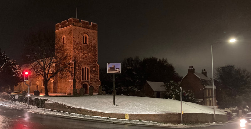 St Mary's Church, Chadwell St Mary, at night, in a churchyard blanketed with snow.